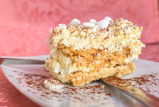 Meringue with cacao and white sugared almonds on white plate,photo close up.