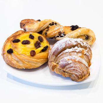 Brioches on white plate,italian breakfast, white background, square photo.