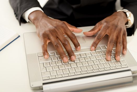 Close-up of male african hand on the keyboard of the laptop.