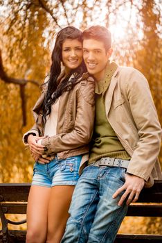 Smiling young couple enjoying autumn day in the park.