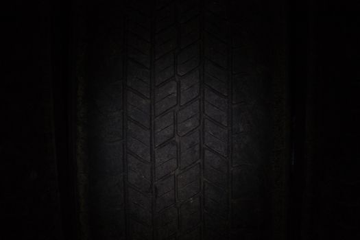 Car tires in a row on a shelf tire. Close-up in dark.