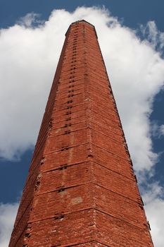 industrial chimney of red brick against a blue sky