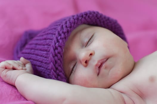 Little baby in hat sleeps peacefully