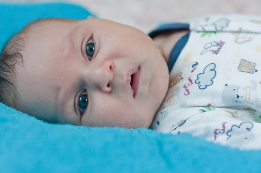 Little baby closeup portrait on the blue towel