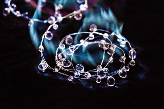 Crystal necklace sparkle on the dark background.