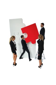 Group of business people assembling jigsaw puzzle isolated on white background