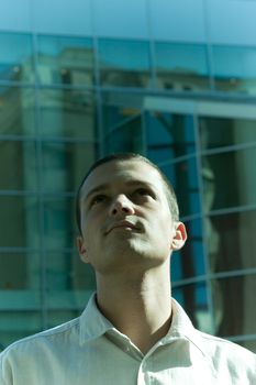 A young businessman in casual dress looks up toward his future' confident.