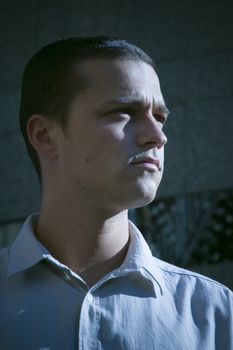 A portrait of a young confident business man in casual dress in front of an office building.