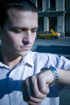 A young businessman with a deadline rushed for time, checking his watch.