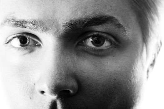 Black and white closeup of a young man's eyes staring