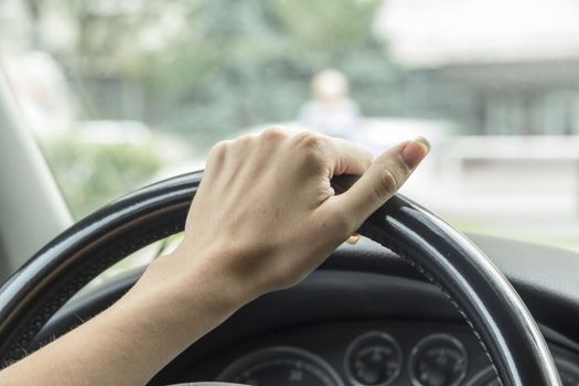 the girl with the manicure keeps hands on the steering wheel of the car