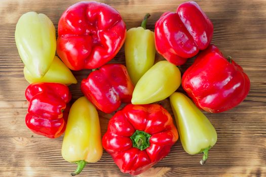 Vegetable still life of mature red and green peppers on wooden background