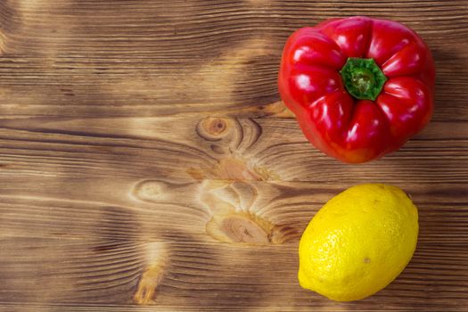 Vegetable wooden background for postcard with red pepper and yellow lemon