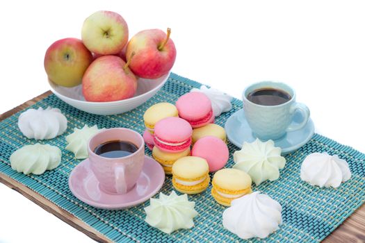 Still life of served coffee cups, macaroon cookies, marshmallows and apples