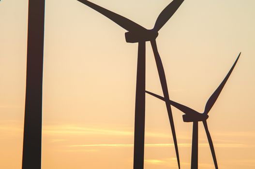 Wind turbine farm with rays of light at sunset