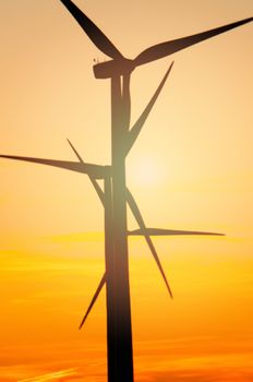 Wind turbine farm with rays of light at sunset