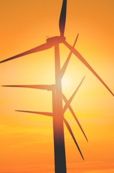 Wind turbine farm with rays of light at sunset