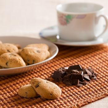 Cookies with chocolate chips and chocolate flakes on a brown tablecloth