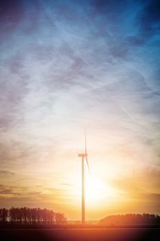Wind turbine farm with rays of light at sunset