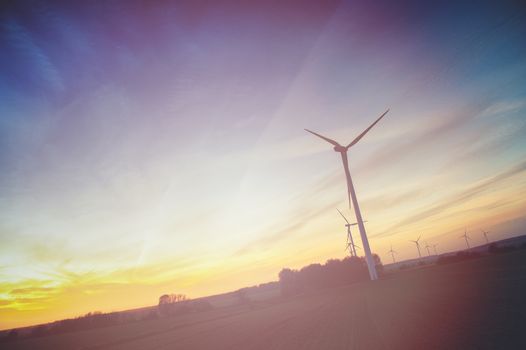 Wind turbine farm with rays of light at sunset