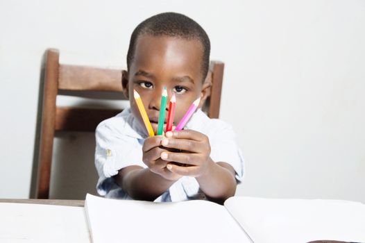 The child shows four colored pencils to his father , yellow, green , red and pink.