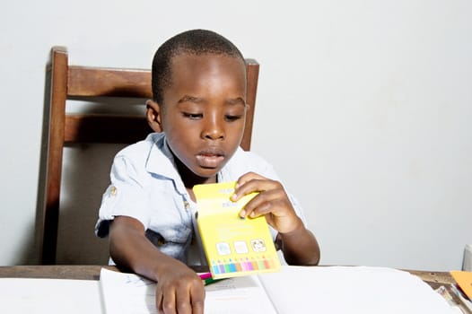 This child looks in the box colored pencils counting mentally.