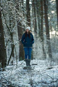 An image of young woman on a walk in snowy winter