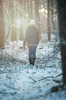 An image of young woman on a walk in snowy winter