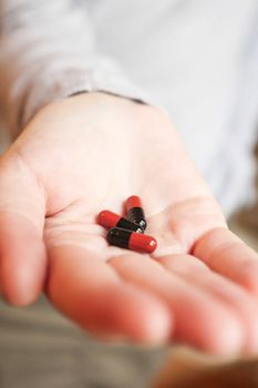 Medicine pills or capsules in hand, palm or fingers. Drug prescription for treatment medication..Antibiotic, painkiller closeup.