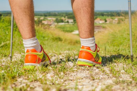 Man walking on sidewalk, sport shoes closeup, France