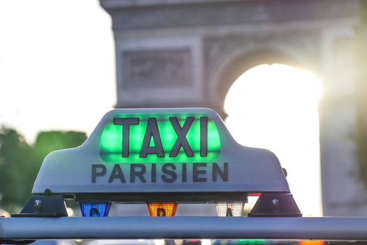 Paris taxi detail and Arc de Triomphe in the background, France