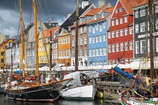 COPENHAGEN, DENMARK - AUGUST 14, 2016: Boats in the docks Nyhavn, people, restaurants and colorful architecture. Nyhavn a 17th century harbour in Copenhagen, Denmark on August 14, 2016.