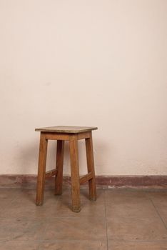 Rustic wooden stool, pink wall background