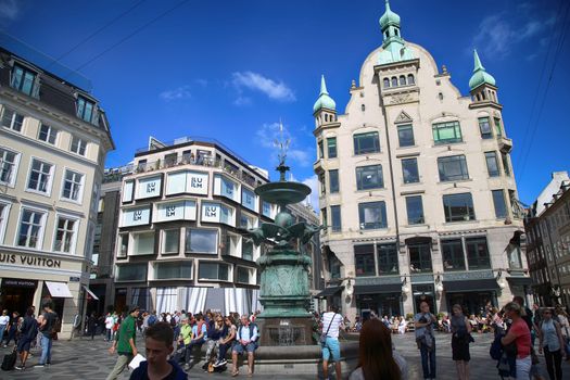 Copenhagen, Denmark – August  15, 2016: Many people near fountain Stork on Amagertorv square at the city centre. Copenhagen is the capital and most populated city of Denmark.