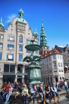 Copenhagen, Denmark – August  15, 2016: Many people near fountain Stork on Amagertorv square at the city centre. Copenhagen is the capital and most populated city of Denmark.