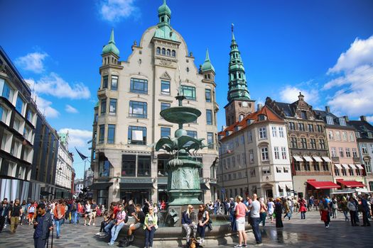 Copenhagen, Denmark – August  15, 2016: Many people near fountain Stork on Amagertorv square at the city centre. Copenhagen is the capital and most populated city of Denmark.