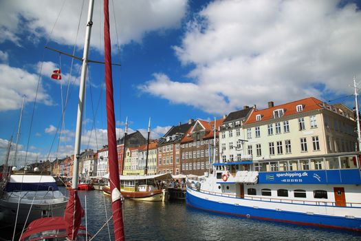 Copenhagen, Denmark – August  15, 2016: Boats in the docks Nyhavn, people, restaurants and colorful architecture. Nyhavn a 17th century harbour in Copenhagen, Denmark