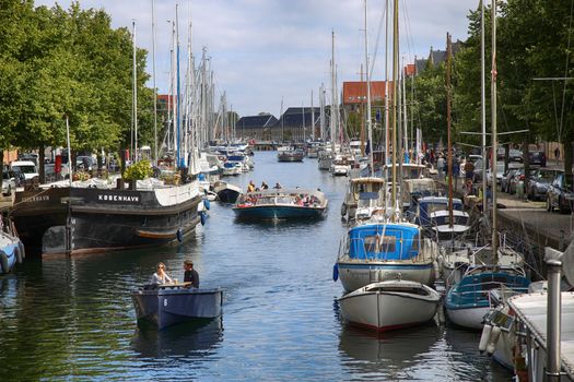 Copenhagen, Denmark – August 15, 2016: View on canal with tourist boat, beetwen Overgaden Oven Vandet street and Overgaden Neden Vandet street from bridge Sankt Anne Gade in Copenhagen, Denmark