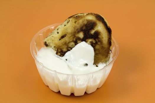 Closeup of a gingerbread pancake with sour cream on a yellow background