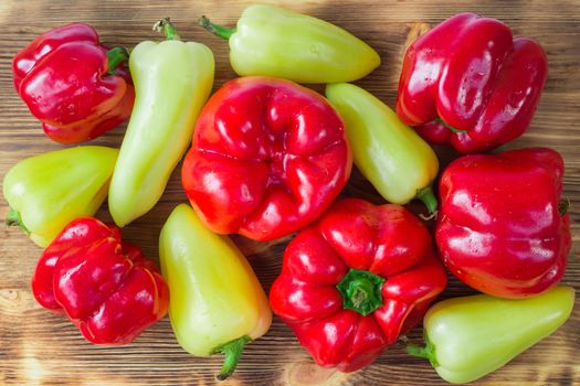 Vegetable still life of mature red and green peppers on wooden background