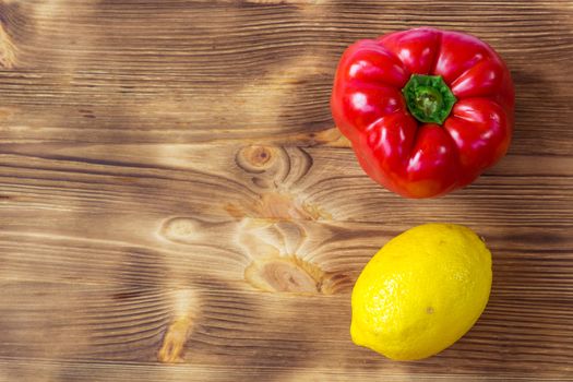 Vegetable wooden background for postcard with red pepper and yellow lemon