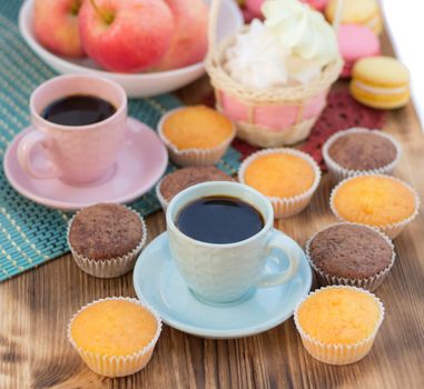 Still life of served coffee cups, macaroon cookies, marshmallows and apples