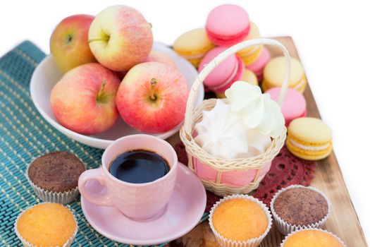 Still life of served coffee cups, macaroon cookies, marshmallows and apples