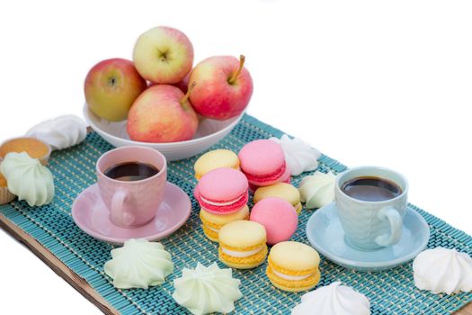 Still life of served coffee cups, macaroon cookies, marshmallows and apples