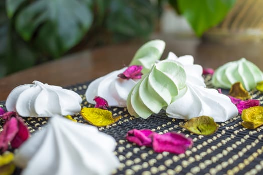 White and green marshmallow dessert composition on black background