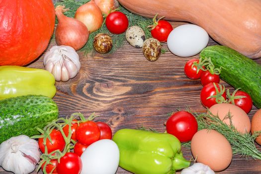 Bright Thanksgiving harvest composition of vegetables onions, cucumbers, peppers pumkin, calabash, tomatoes, garlic, eggs on dark wooden background