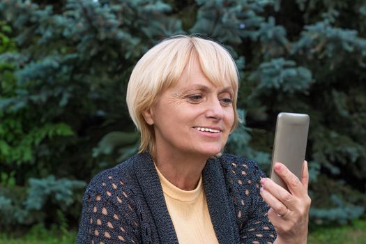 Elderly woman chats by video messenger on cellar phone