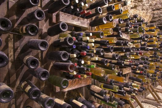 Many red and white wine bottles stacked on wooden racks