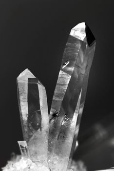 Two natural transparent quartz crystal on a black background