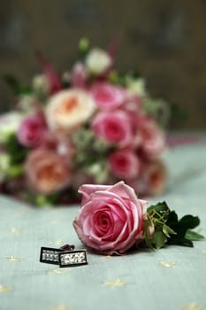 Beautiful wedding bouquet from pink roses and groom cufflinks